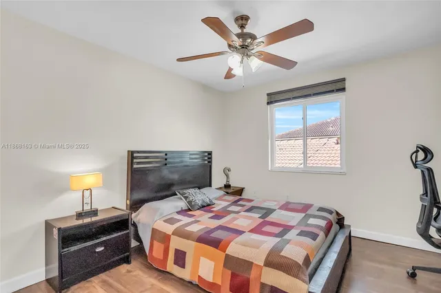 a bedroom with a bed and a lamp on dresser