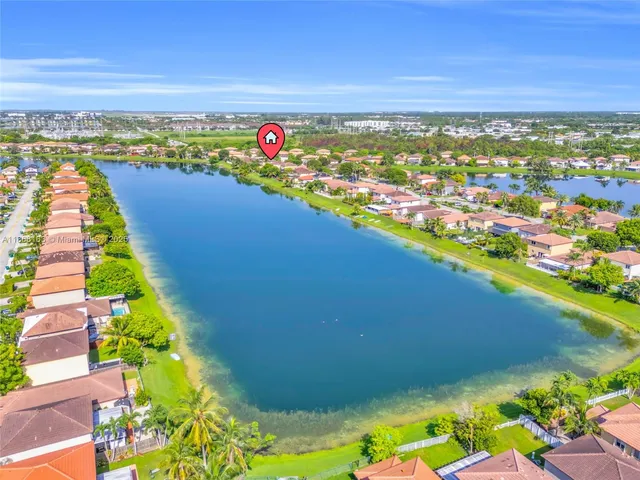 an aerial view of lake and residential houses with outdoor space