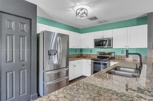 a kitchen with a refrigerator a microwave a stove and cabinets