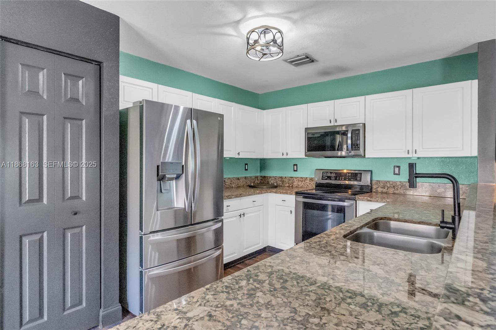 12160 Southwest 135th Terrace Miami, FL 33186 - Photo 9 of 46 a kitchen with a refrigerator a microwave a stove and cabinets