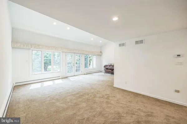 an empty room with a fireplace and windows