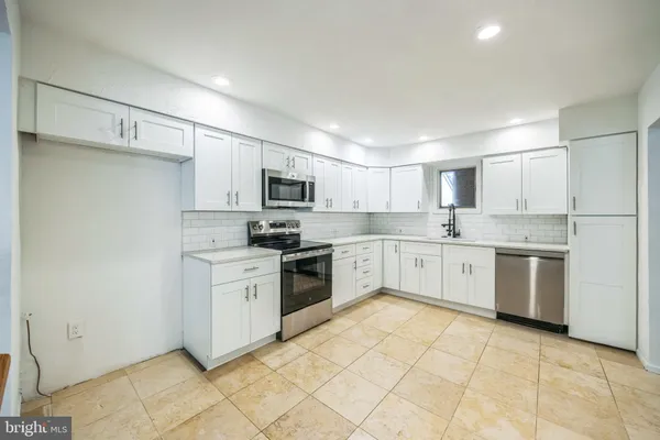 a kitchen with cabinets stainless steel appliances and a sink