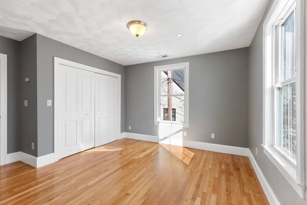 8 Common Street, Unit 3 Stoneham, MA 02180 - Photo 12 of 29 a view of an empty room with wooden floor and a window