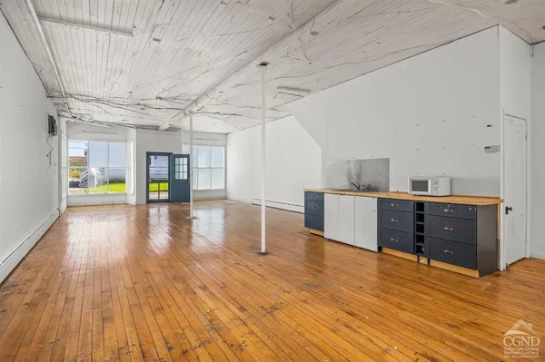 a room with wooden floors and appliances