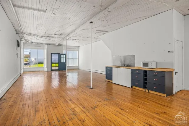 a room with wooden floors and appliances