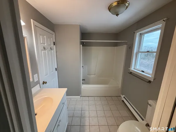 a bathroom with a tub shower and a sink