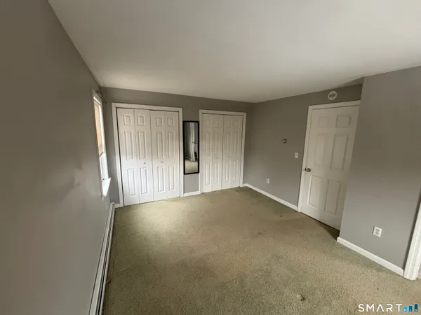 an empty room with windows and closet