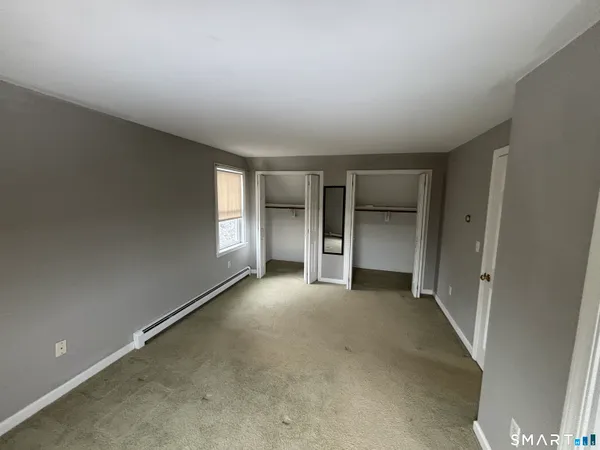 an empty room with a fireplace and windows