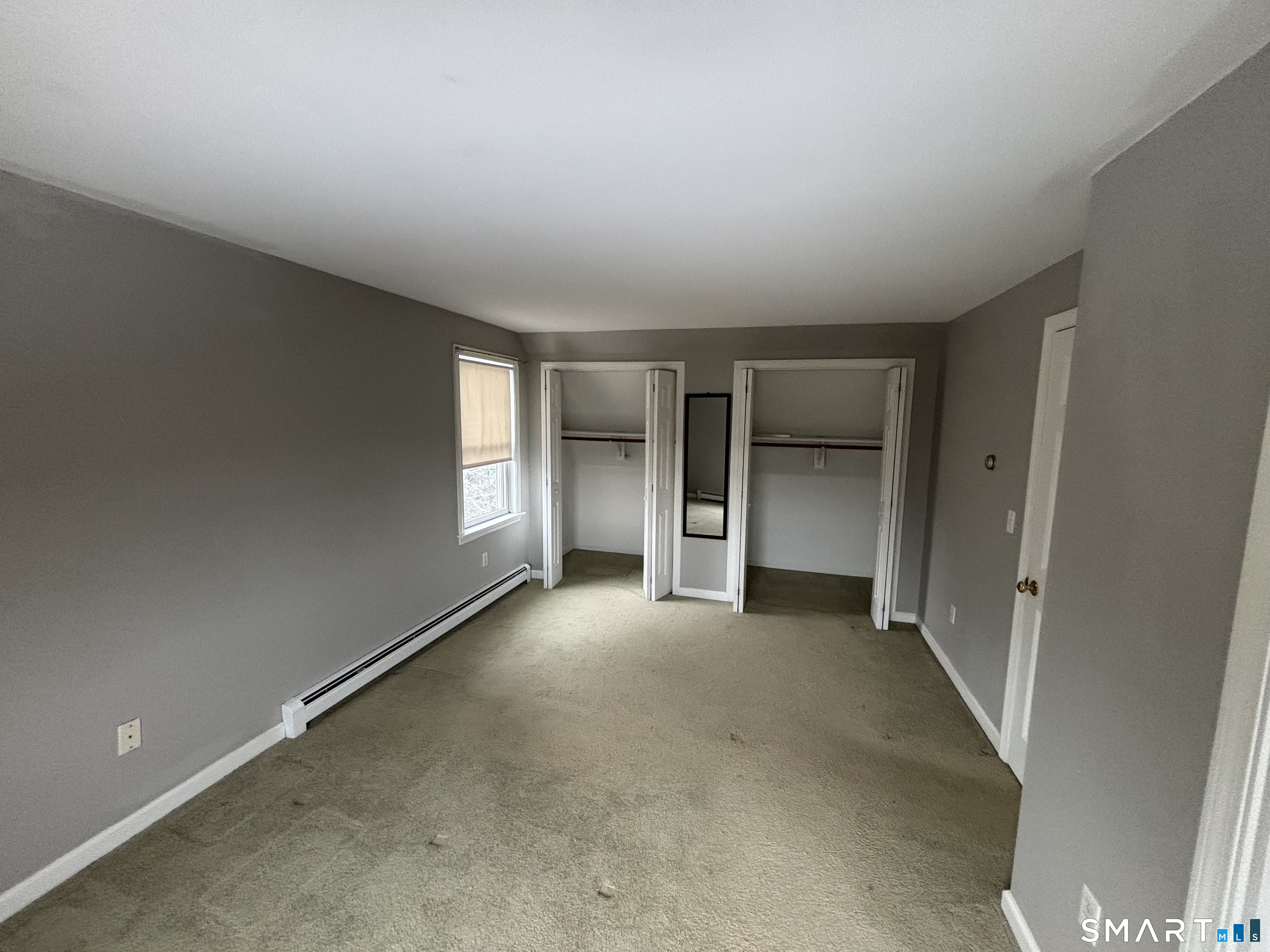 72 Ingham Hill Road Old Saybrook, CT 06475 - Photo 13 of 25 an empty room with a fireplace and windows