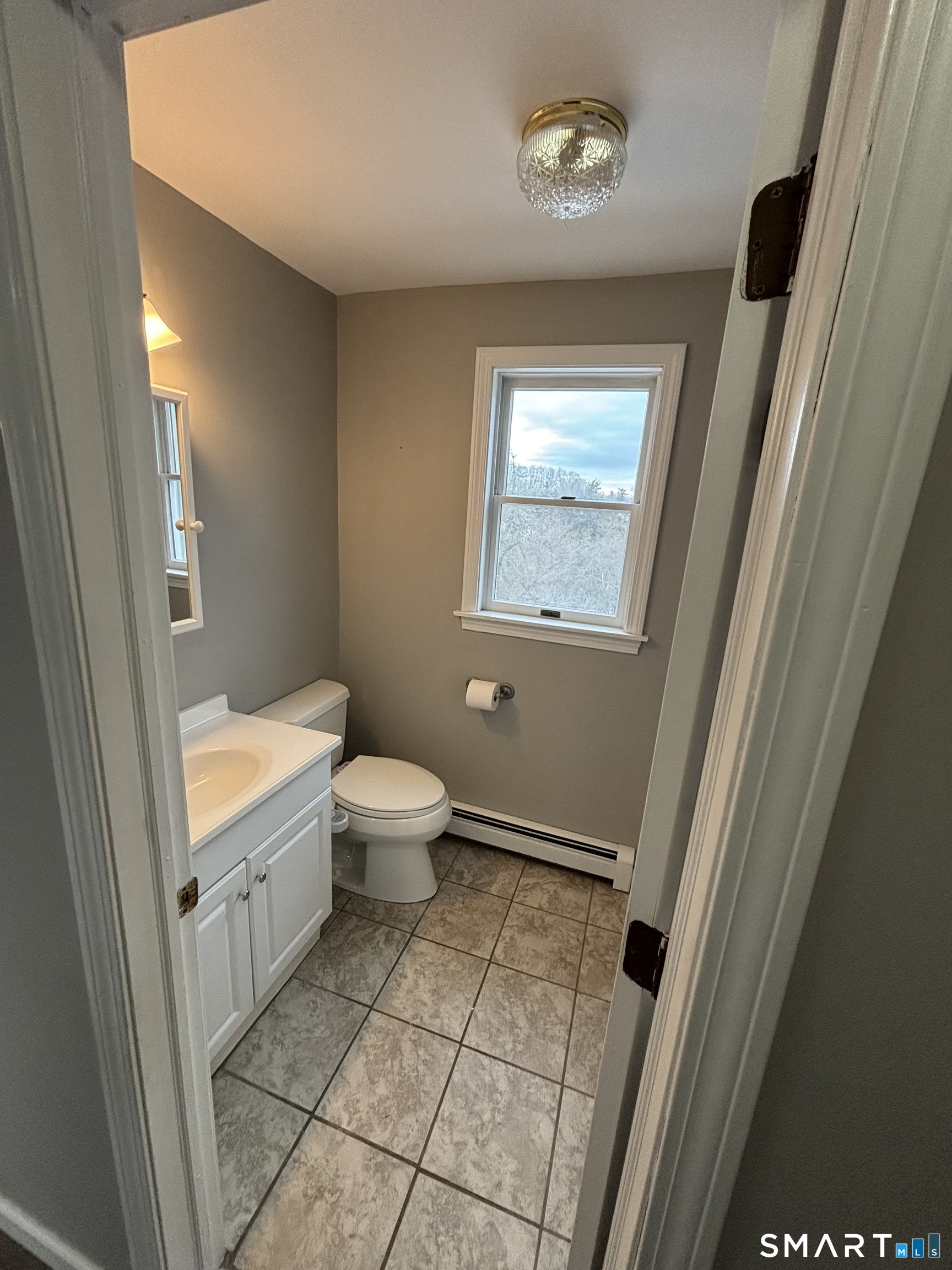 72 Ingham Hill Road Old Saybrook, CT 06475 - Photo 24 of 25 a bathroom with a sink a toilet and a window