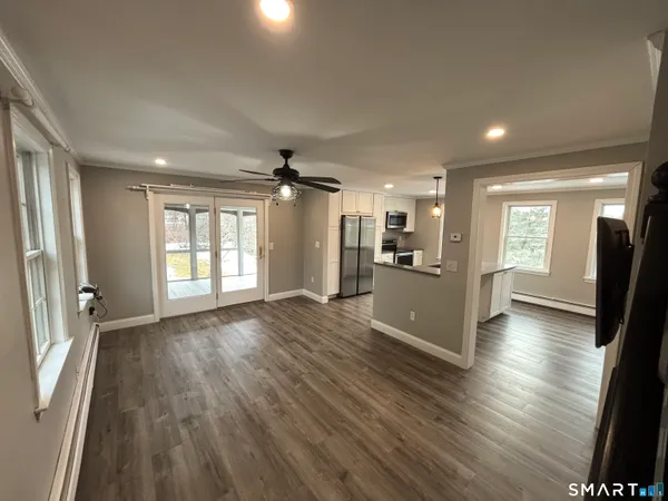 an empty room with wooden floor and windows