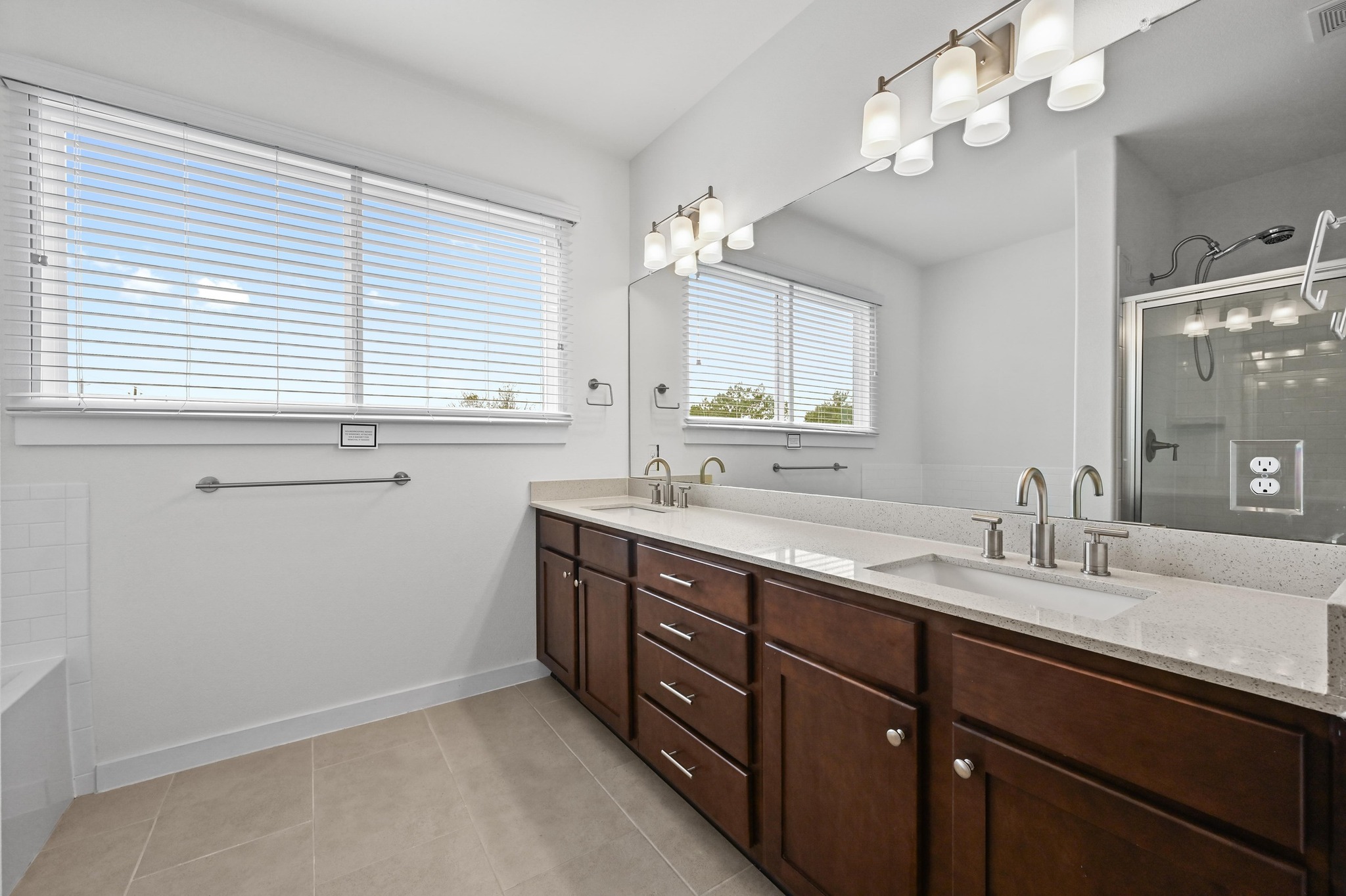 8901 Parker Ranch Circle, Unit A Austin, TX 78748 - Photo 20 of 31 A spacious double vanity matches with tile flooring and a glass-enclosed shower.