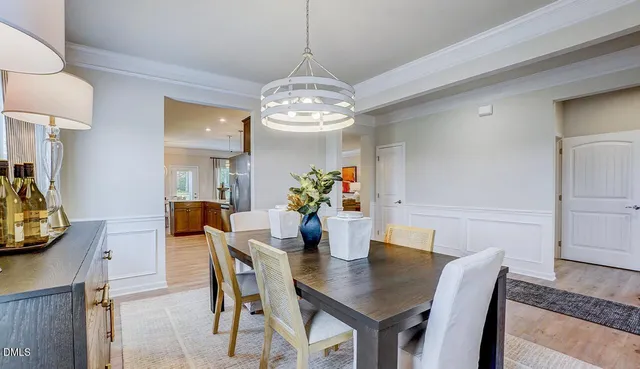 a dining room with furniture potted plants and wooden floor