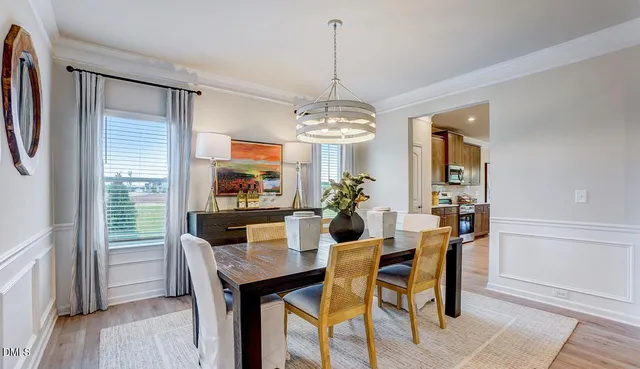 a dining room with furniture a chandelier and wooden floor