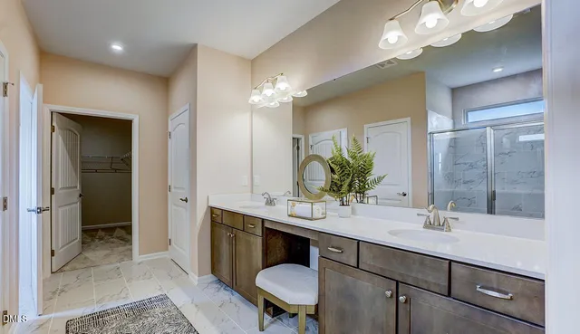 a bathroom with a double vanity sink mirror and shower