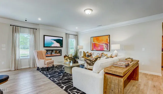 a living room with furniture a flat screen tv and a window