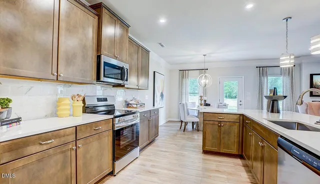 a kitchen with a sink stove cabinets and wooden floor