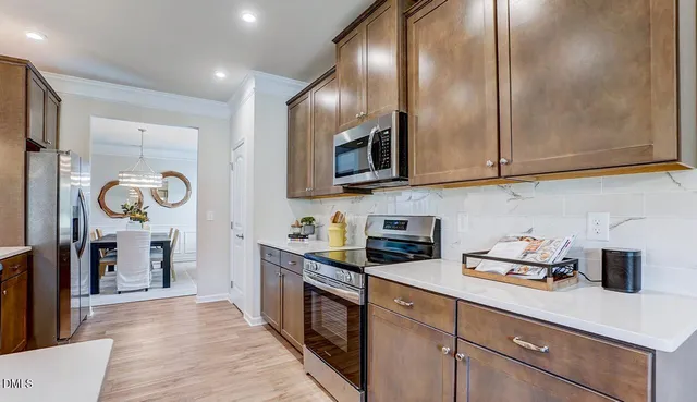 a kitchen with stainless steel appliances granite countertop a sink dishwasher stove and cabinets with wooden floor