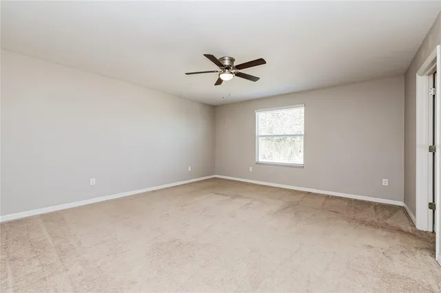 an empty room with a window and a ceiling fan