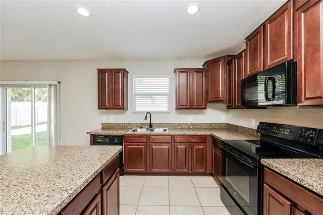 a kitchen with a sink stove top oven and cabinets