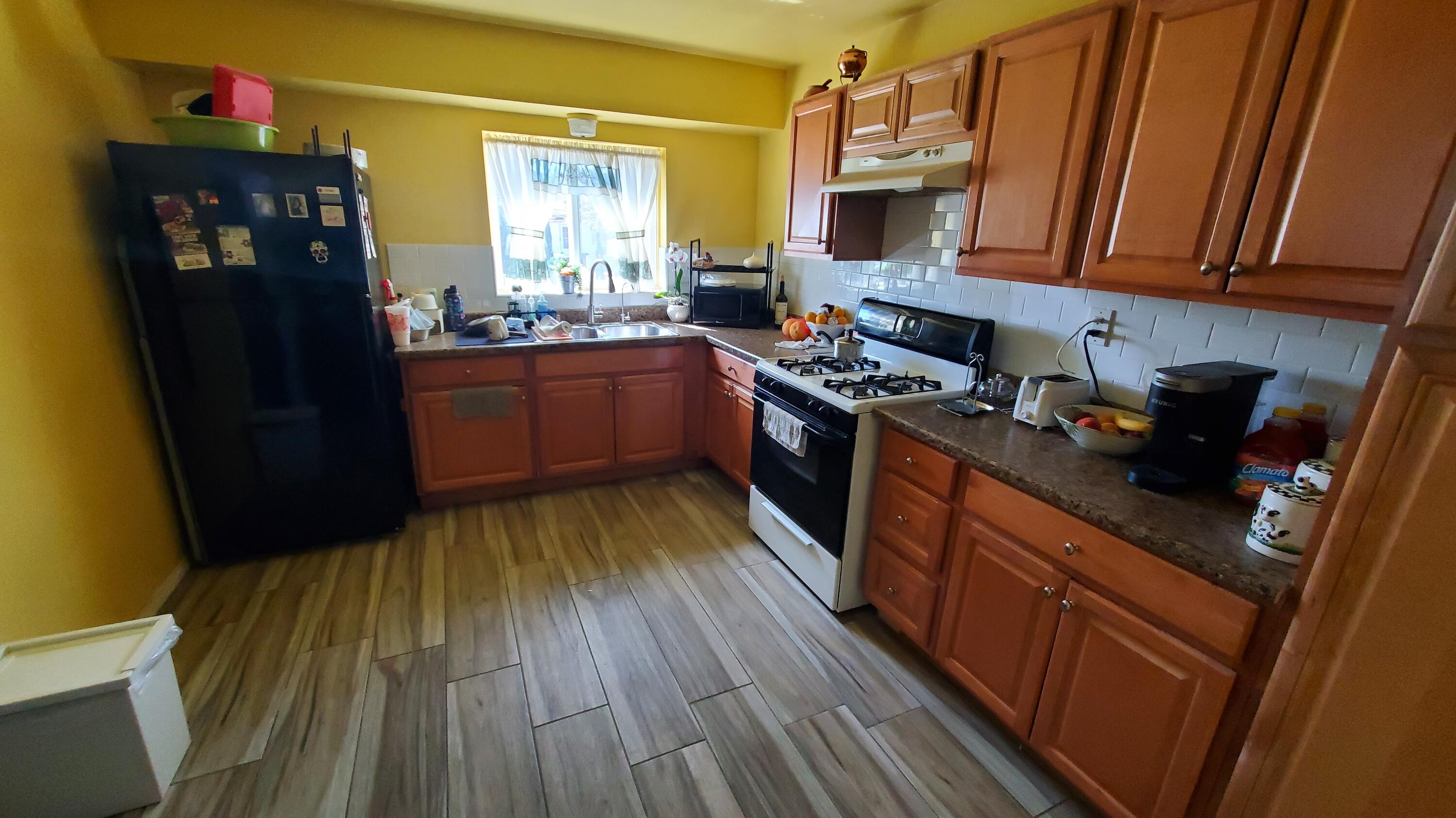 831 West George Street Banning, CA 92220 - Photo 8 of 39 a kitchen with wooden floors and stainless steel appliances