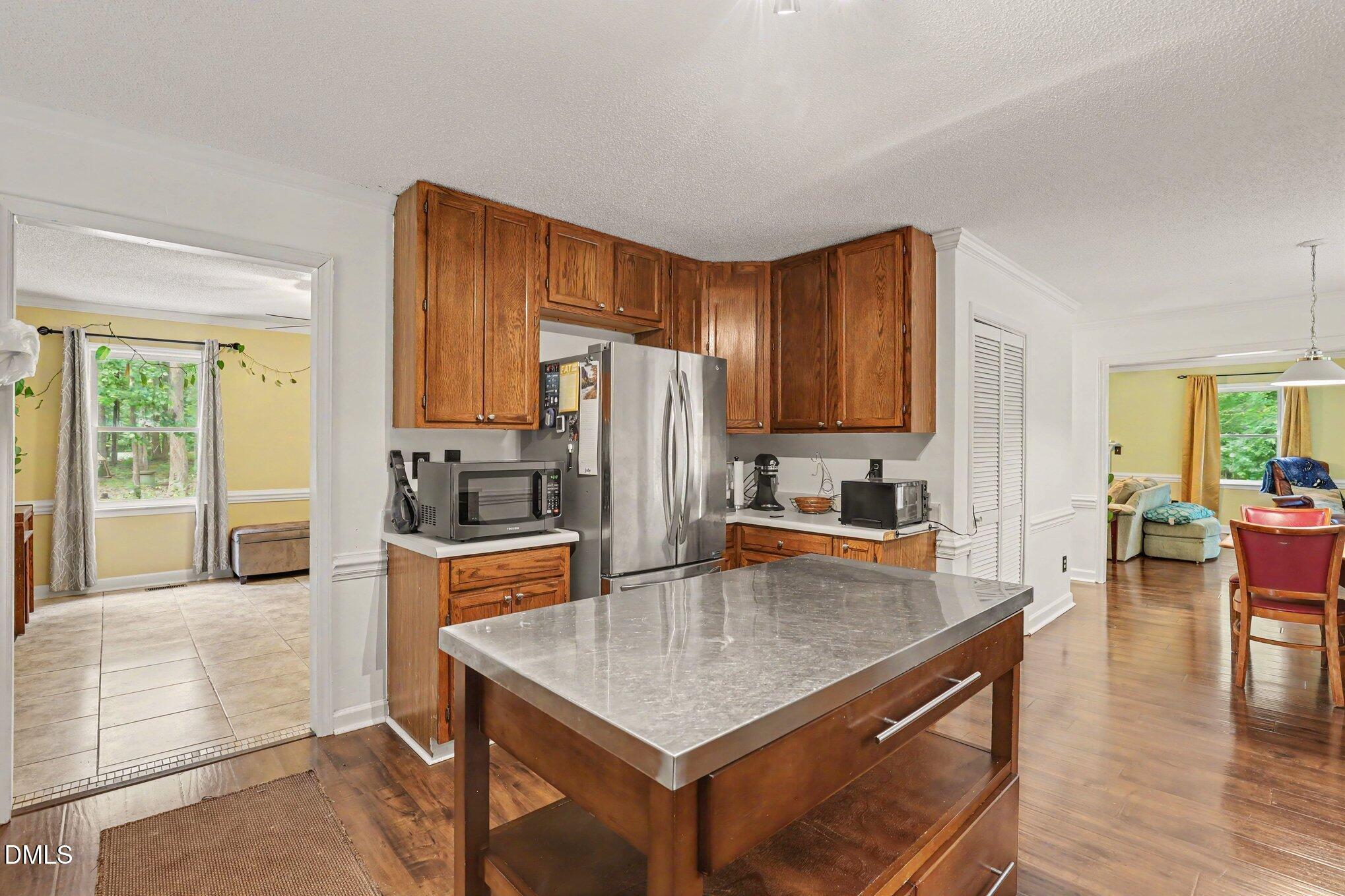 114 Oak Hollow Road Timberlake, NC 27583 - Photo 13 of 31 Kitchen featuring wood-finish flooring, wood cabinetry, and a stainless steel refrigerator