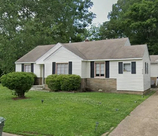 a front view of a house with a yard and green space