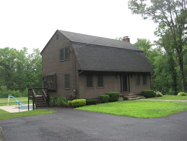 333 New Boston Road Sturbridge, MA 01566 - Photo 16 of 24 a brick house with a small yard and wooden fence