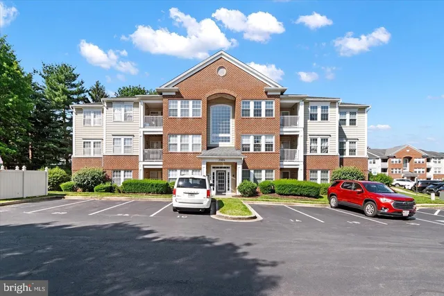 a front view of a building with cars parked