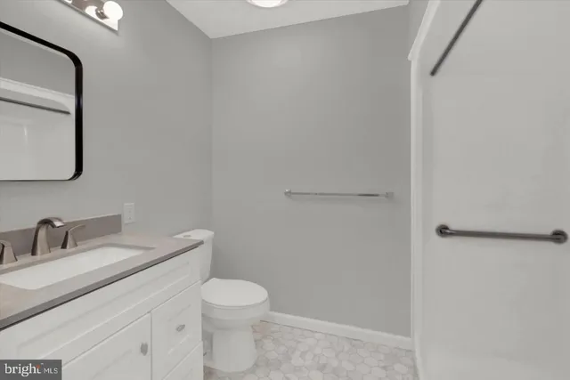 a bathroom with a toilet sink vanity and mirror