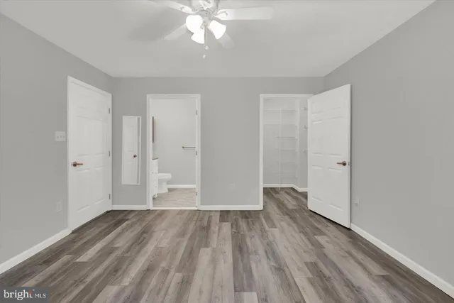 a view of a room with wooden floor and ceiling fan
