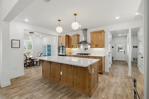 a large kitchen with cabinets a sink a counter space and stainless steel appliances