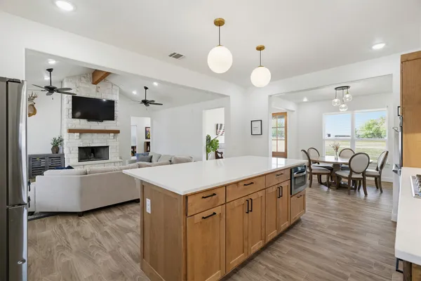 a large white kitchen with a table and chairs