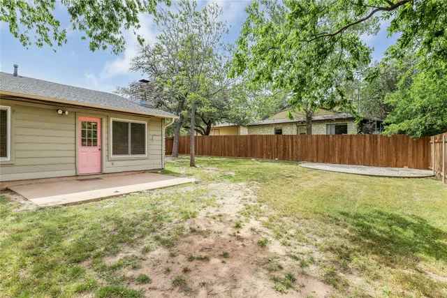 a backyard of a house with swimming pool and wooden fence