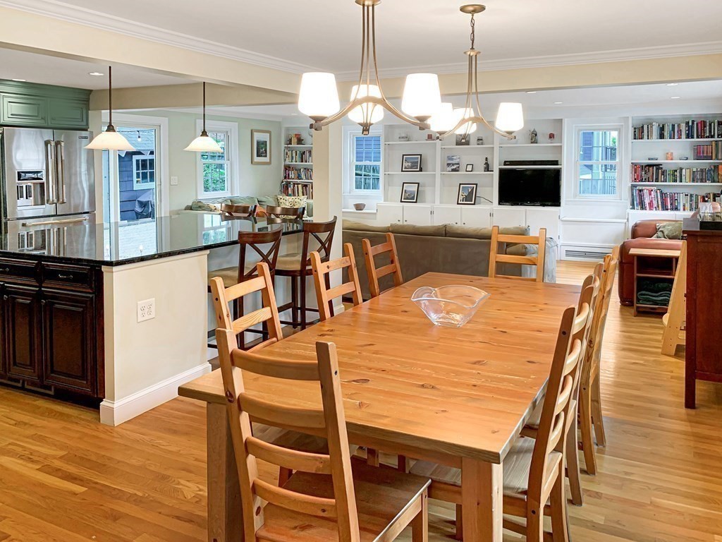 139 Simonds Road Lexington, MA 02420 - Photo 5 of 28 a view of a dining room and livingroom with furniture wooden floor a flat screen tv a painting and a chandelier