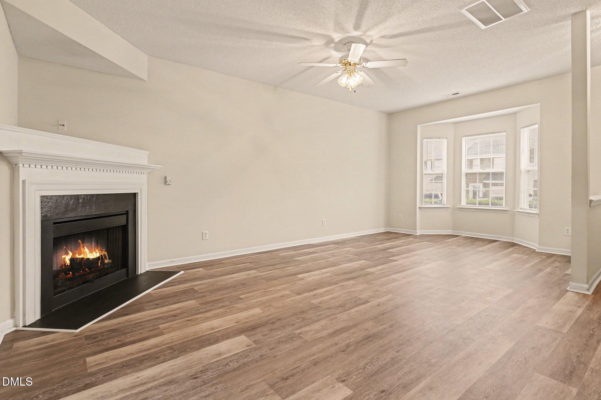 10947 Pendragon Place Raleigh, NC 27614 - Photo 4 of 21 a view of empty room with wooden floor and fireplace