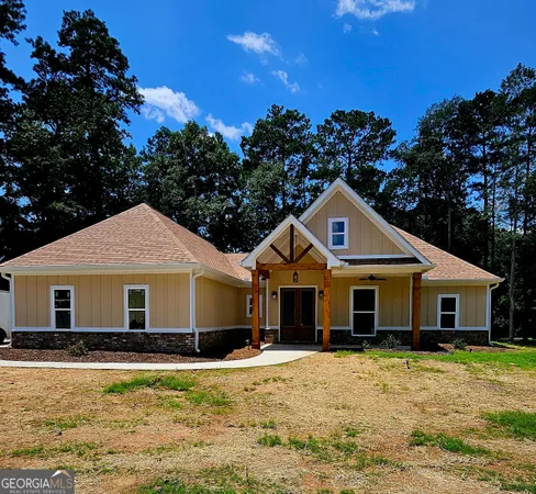 a front view of a house with a yard covered with trees