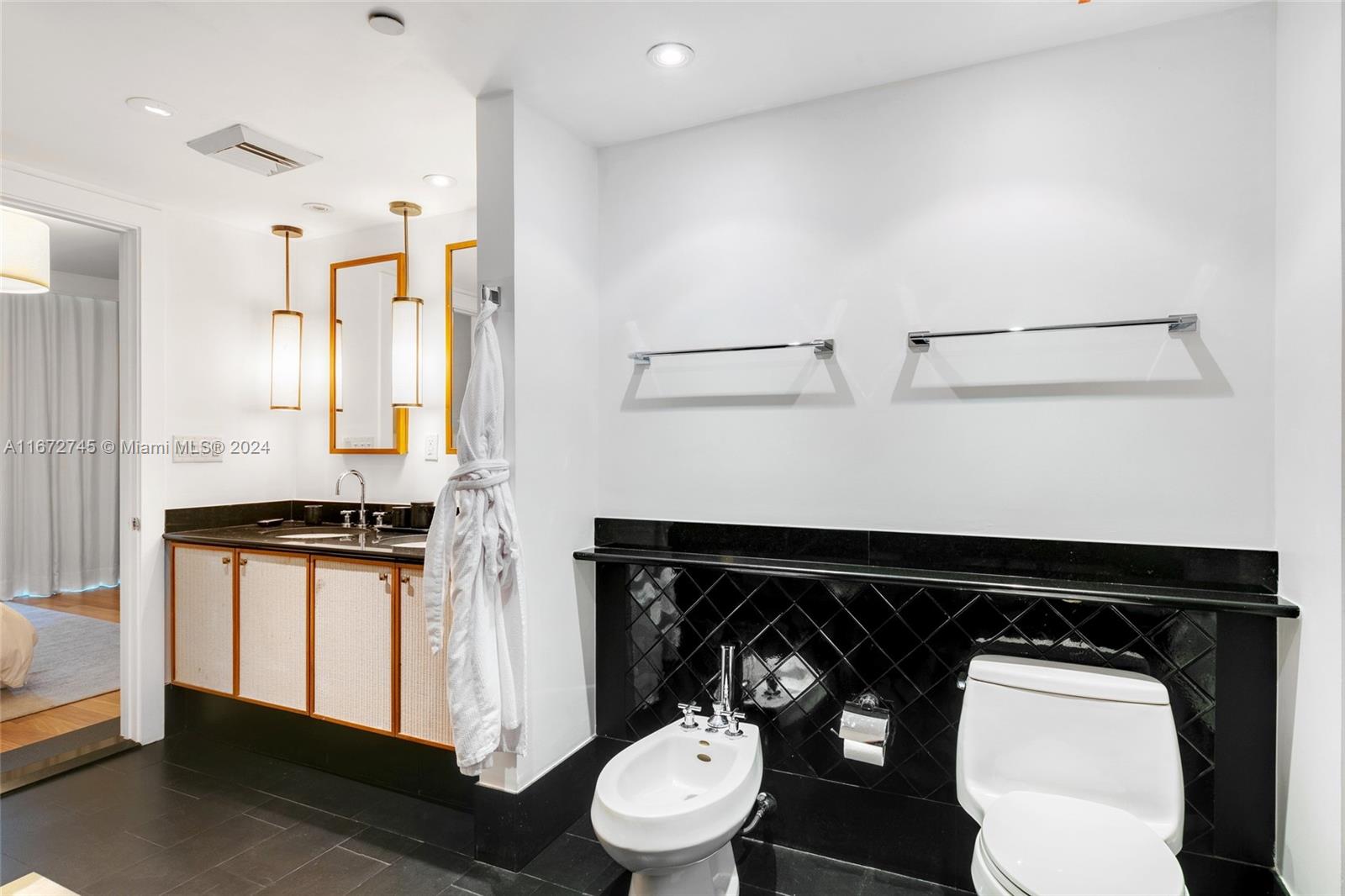 101 20th Street, Unit 2706 Miami Beach, FL 33139 - Photo 15 of 22 a bathroom with a toilet a sink and a mirror