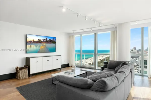 a living room with furniture a large window and a flat screen tv