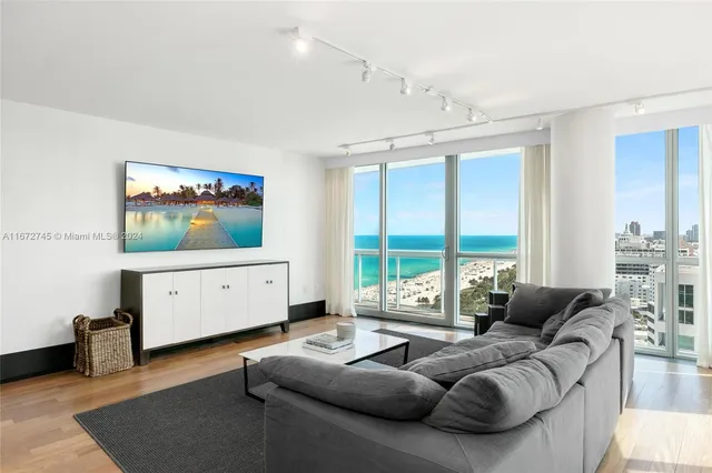 a living room with furniture a large window and a flat screen tv