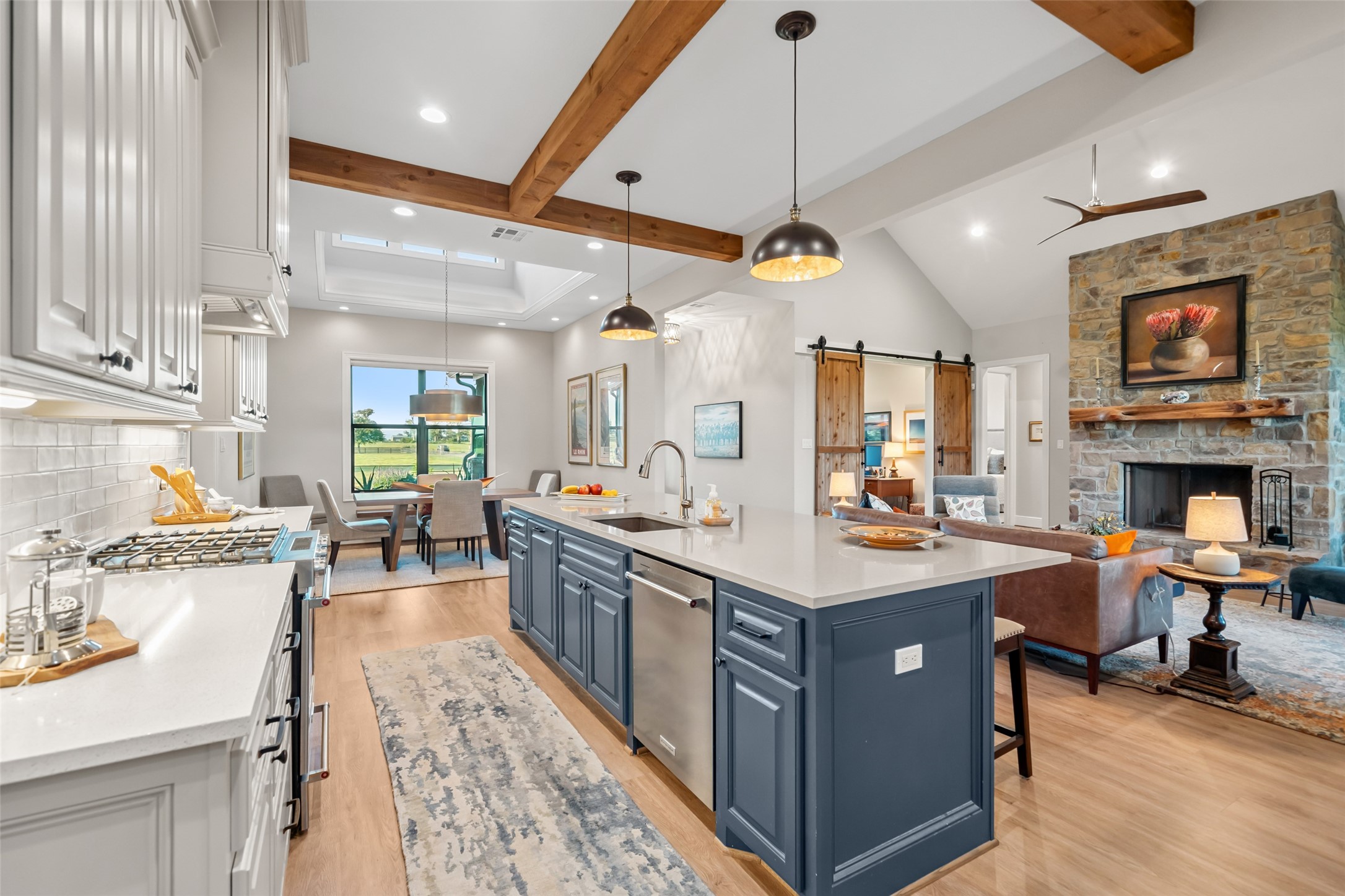 30163 High Spirit Ranch Road Hempstead, TX 77445 - Photo 12 of 49 a kitchen with stainless steel appliances granite countertop a stove top oven a sink a dining table and chairs with wooden floor