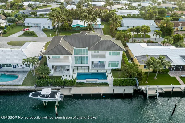 a aerial view of a house with swimming pool lawn chairs and a yard