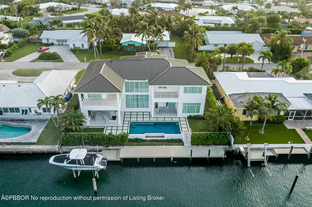 a aerial view of a house with swimming pool lawn chairs and a yard