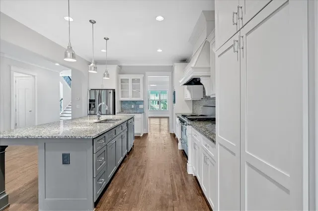 a large kitchen with granite countertop a stove top oven a sink and a fireplace