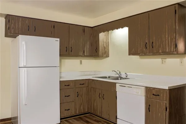 a kitchen with a sink a refrigerator and cabinets