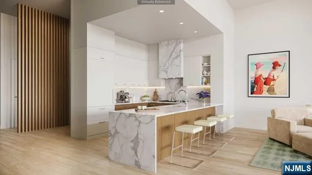 a living room with stainless steel appliances furniture a rug and a kitchen view
