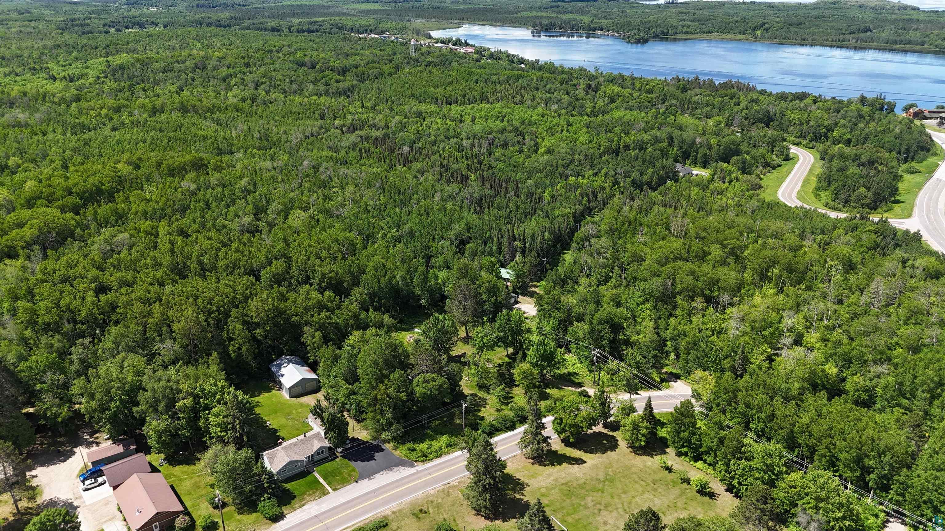 10614 Moose Lake Road Orr, MN 55771 - Photo 10 of 44 Expansive forested parcel with a visible body of water in the background, featuring established roadways and surrounding residential structures