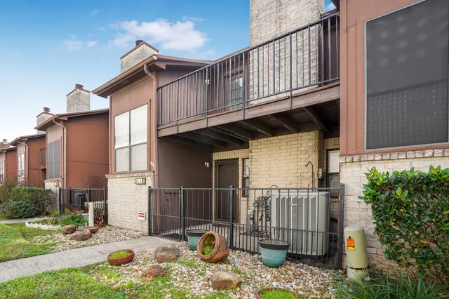 a backyard of a house with glass top table and chairs