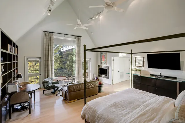 a bedroom with furniture a flat screen tv and a fireplace