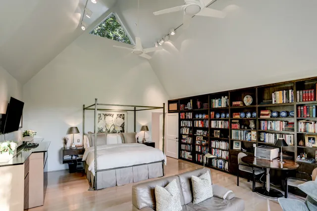 a bedroom with a bed furniture and a flat tv screen